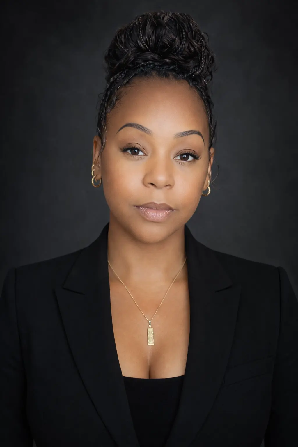 Professional portrait of woman with braided updo and black blazer
