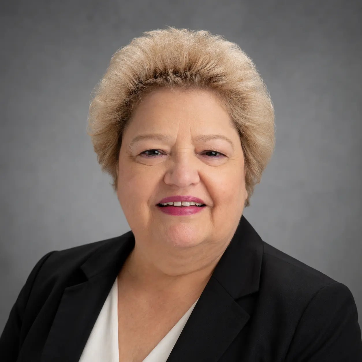 Professional headshot of smiling woman in black blazer