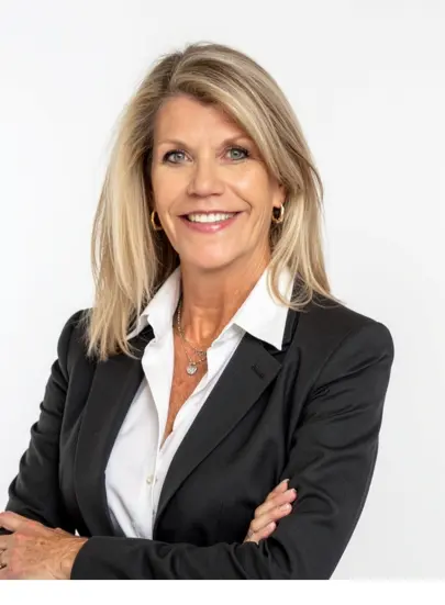 Smiling businesswoman in black blazer with crossed arms